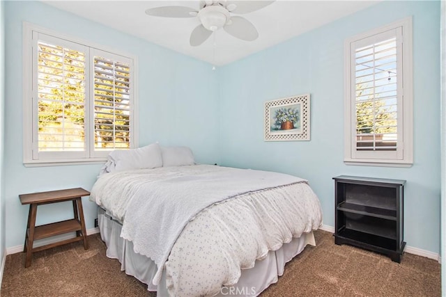 carpeted bedroom featuring multiple windows and ceiling fan