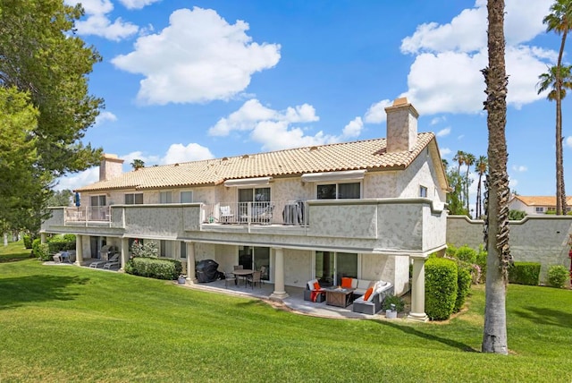 back of property with outdoor lounge area, a patio area, a balcony, and a yard