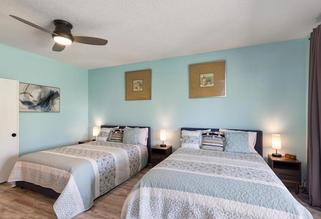 bedroom with ceiling fan, a textured ceiling, and hardwood / wood-style floors