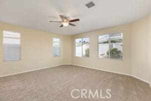 carpeted spare room with ceiling fan