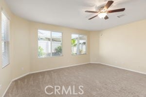 carpeted spare room with ceiling fan