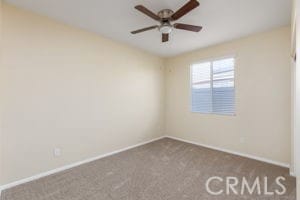 carpeted spare room featuring ceiling fan