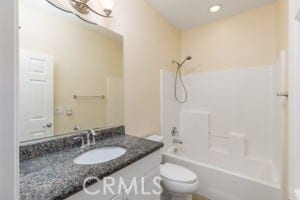 full bathroom featuring toilet, vanity, and shower / washtub combination