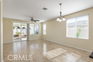 spare room with ceiling fan with notable chandelier