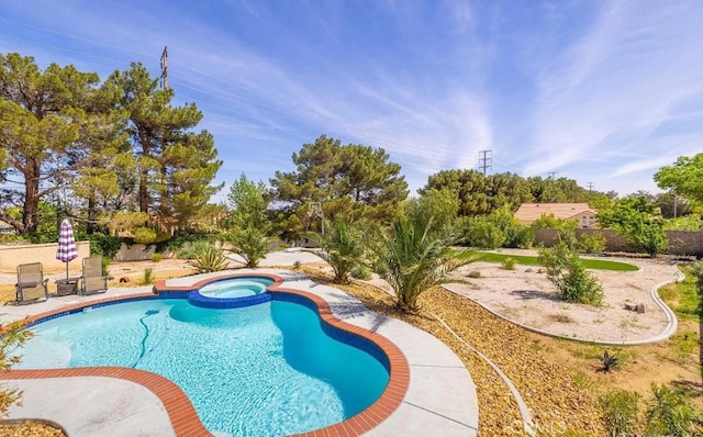 view of swimming pool featuring fence and a pool with connected hot tub