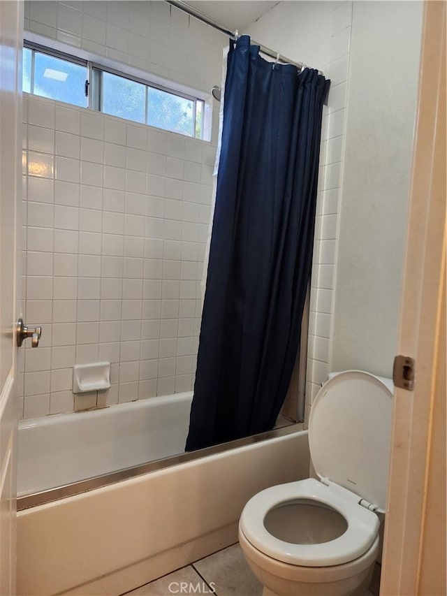 bathroom featuring tile patterned floors, toilet, and shower / bath combo with shower curtain