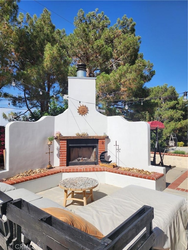 view of patio with an outdoor brick fireplace