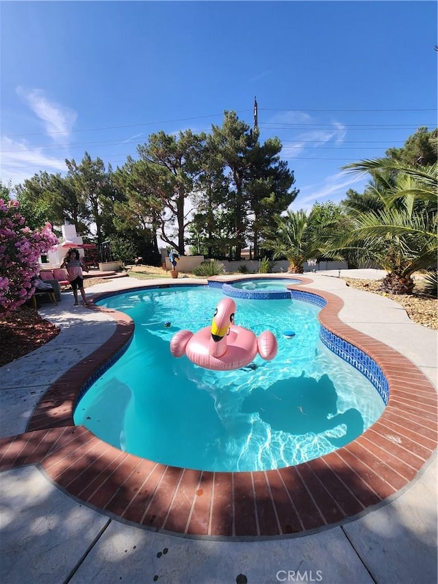 view of pool with an in ground hot tub