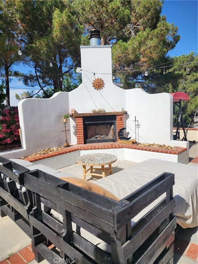 view of patio with an outdoor brick fireplace