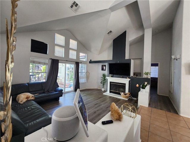 living room with high vaulted ceiling and tile patterned floors