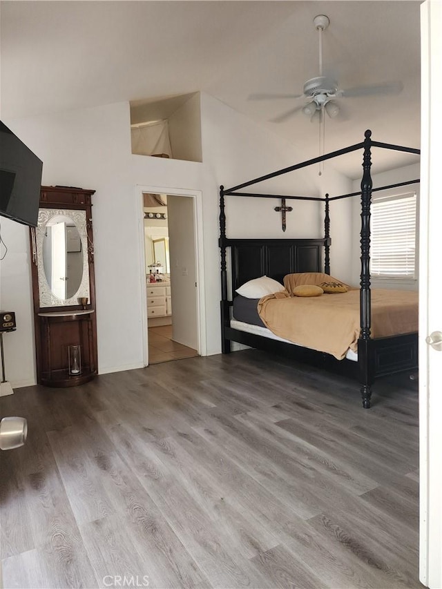 unfurnished bedroom featuring ceiling fan, lofted ceiling, connected bathroom, and hardwood / wood-style flooring