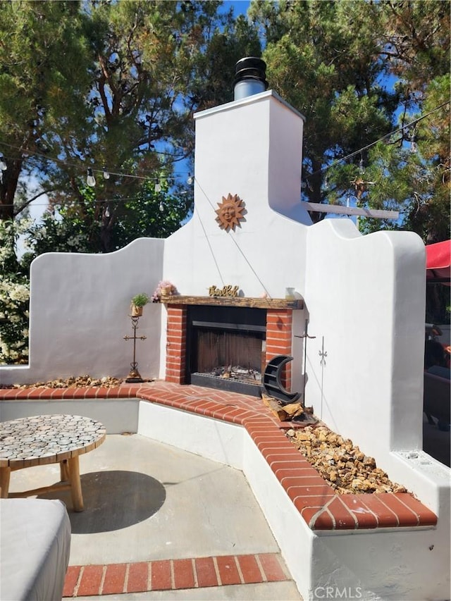 view of patio featuring an outdoor brick fireplace