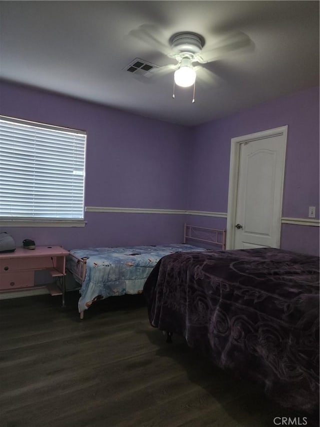 bedroom with dark hardwood / wood-style floors and ceiling fan