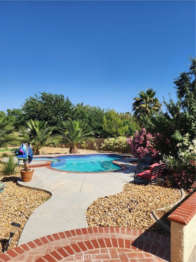 view of swimming pool with a patio and an in ground hot tub