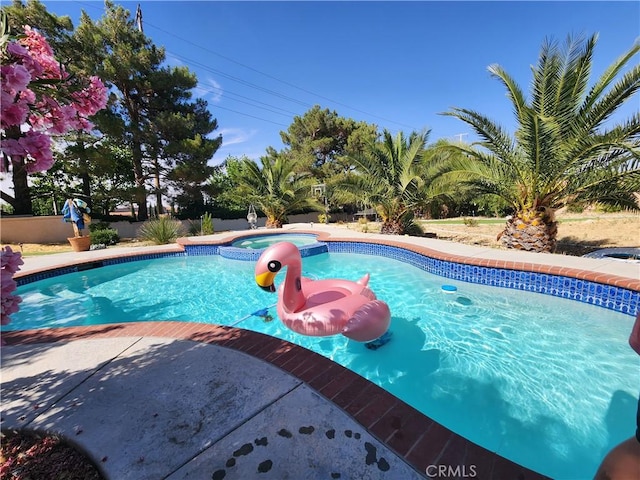 view of pool with an in ground hot tub