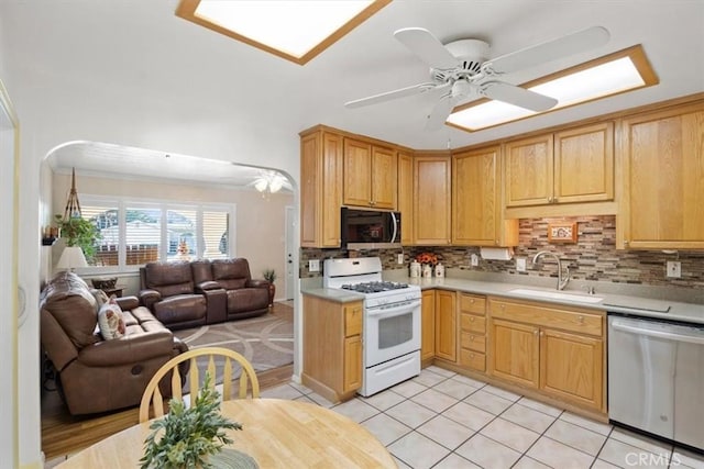 kitchen with sink, decorative backsplash, ceiling fan, light tile patterned floors, and stainless steel appliances