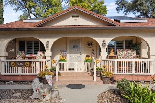 view of front of house featuring covered porch and solar panels