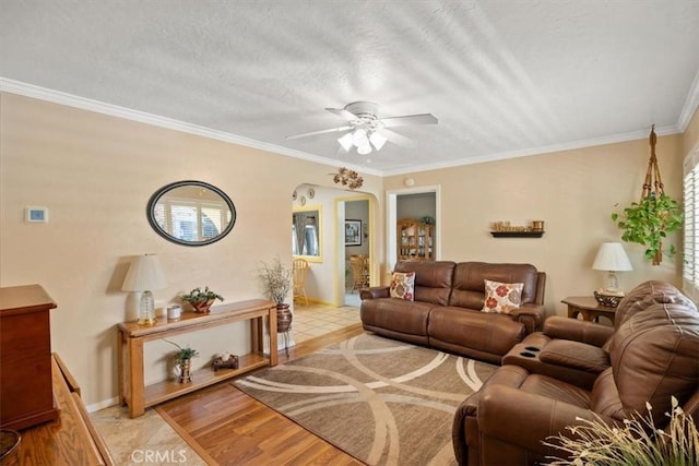 living room featuring ceiling fan, ornamental molding, and light hardwood / wood-style flooring