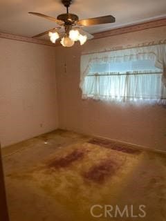 spare room with ceiling fan and ornamental molding