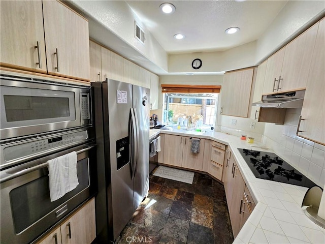 kitchen featuring appliances with stainless steel finishes, light brown cabinets, tasteful backsplash, and sink