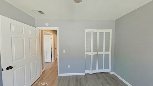 unfurnished bedroom with a closet and light wood-type flooring