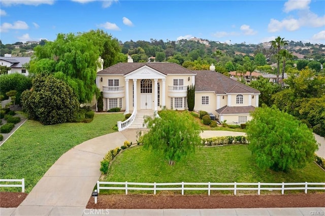 view of front of house featuring a balcony and a front yard