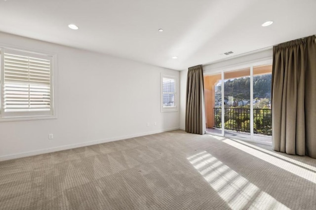 carpeted empty room featuring lofted ceiling