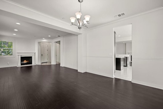 unfurnished living room featuring a notable chandelier, crown molding, and dark wood-type flooring