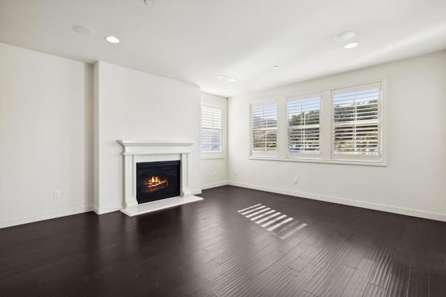 unfurnished living room with dark wood-type flooring and a wealth of natural light