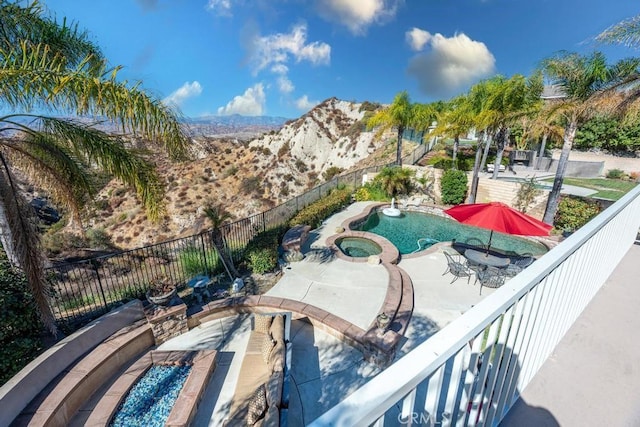 exterior space with a mountain view and an in ground hot tub