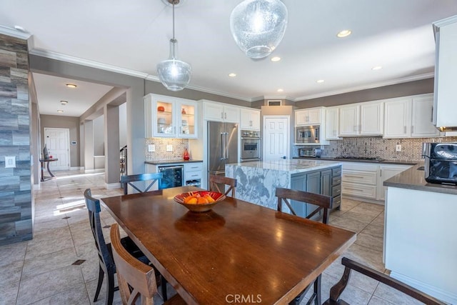 tiled dining area featuring ornamental molding and beverage cooler