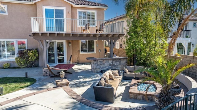 rear view of house with an outdoor bar, an outdoor hangout area, a balcony, and a patio