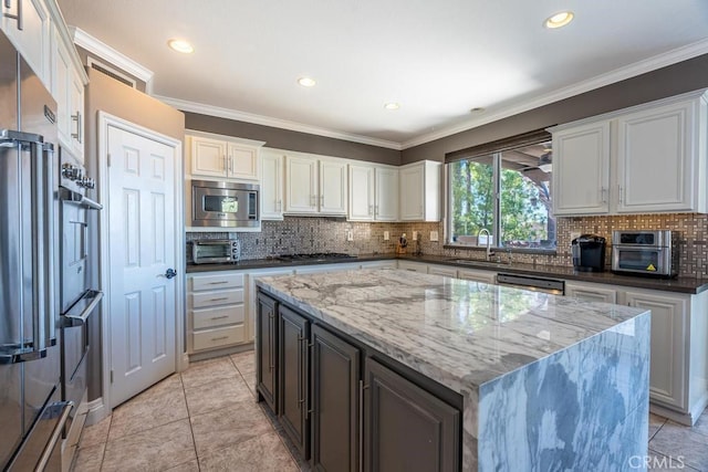 kitchen with white cabinets, a center island, crown molding, and stainless steel appliances