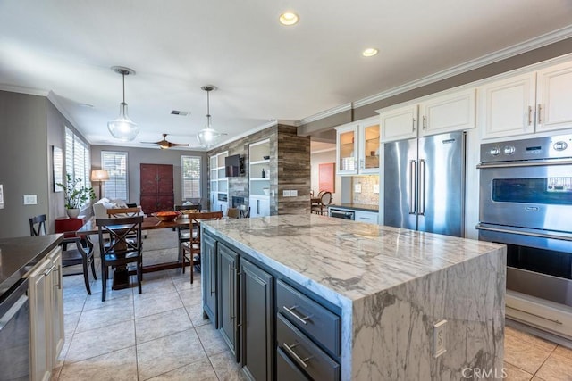 kitchen featuring ceiling fan, appliances with stainless steel finishes, white cabinets, and ornamental molding