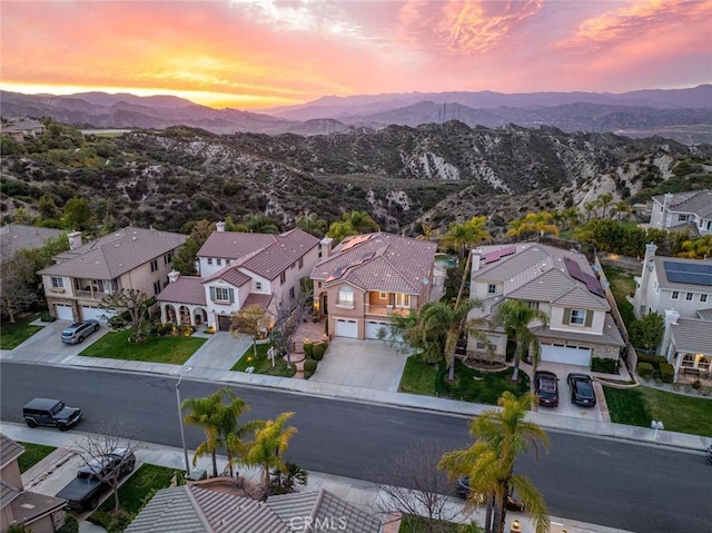 aerial view at dusk featuring a residential view and a mountain view