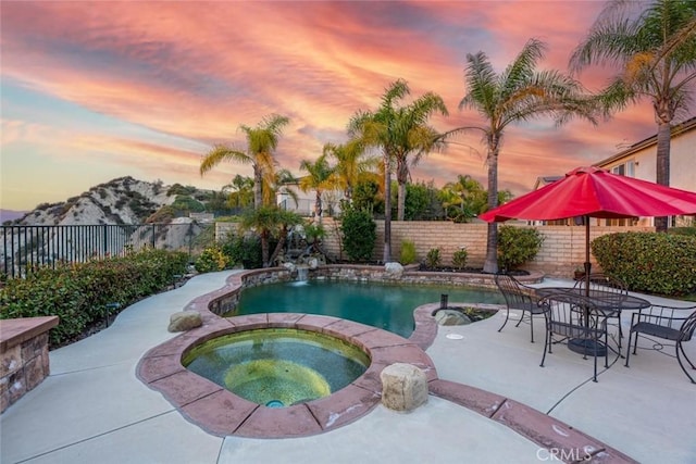 view of pool with a fenced in pool, a patio, a mountain view, an in ground hot tub, and a fenced backyard