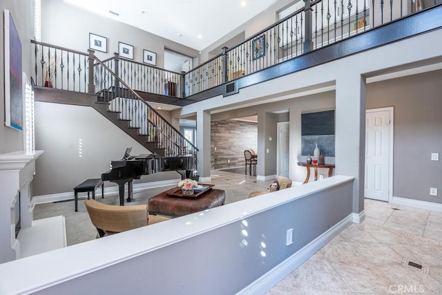 interior space with a towering ceiling, baseboards, and stairs