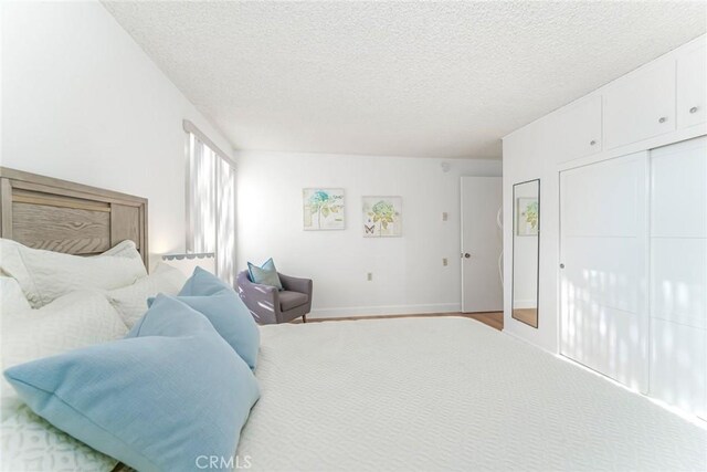 carpeted bedroom featuring a closet and a textured ceiling