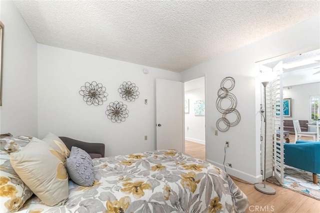 bedroom featuring hardwood / wood-style flooring and a textured ceiling