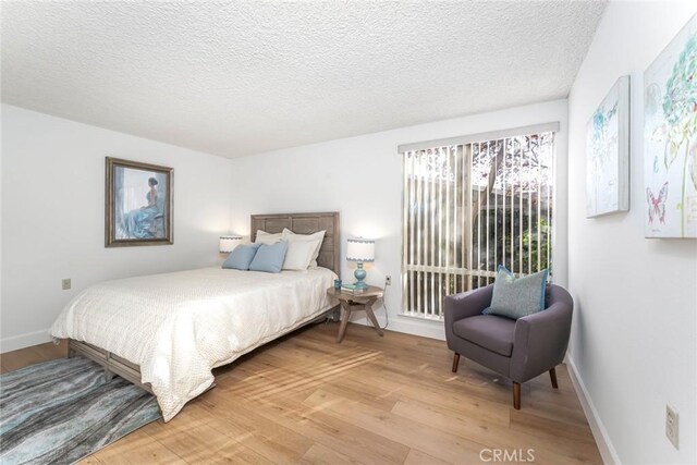 bedroom with a textured ceiling and hardwood / wood-style flooring