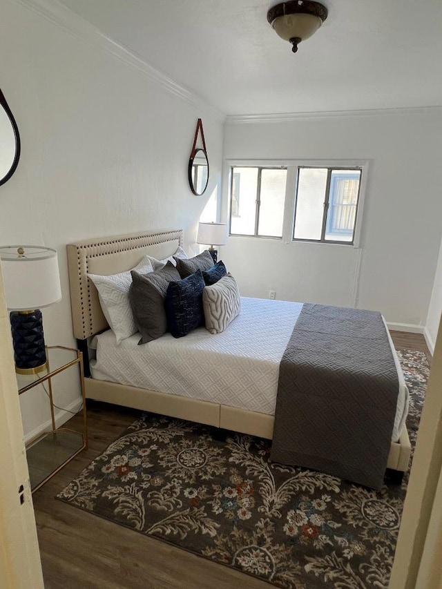 bedroom with crown molding and dark wood-type flooring