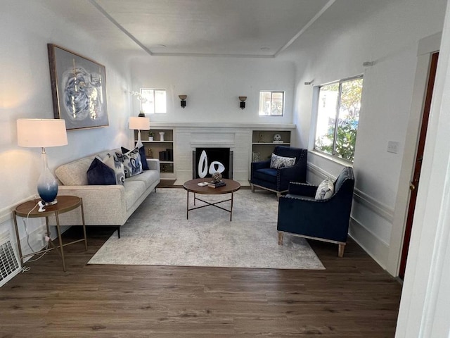 living room featuring hardwood / wood-style flooring and a brick fireplace