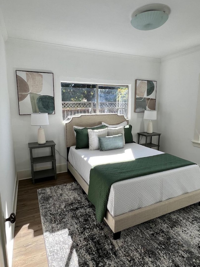 bedroom with hardwood / wood-style flooring and crown molding