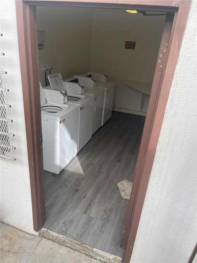 laundry area featuring washing machine and dryer and hardwood / wood-style flooring