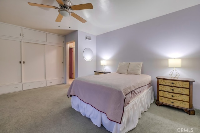 carpeted bedroom with ceiling fan and a closet