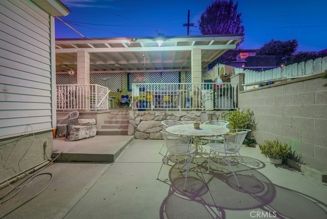 patio terrace at dusk featuring a pergola