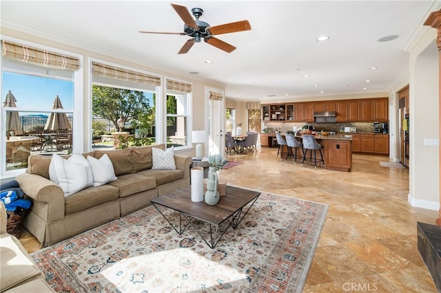 living room featuring ceiling fan and crown molding