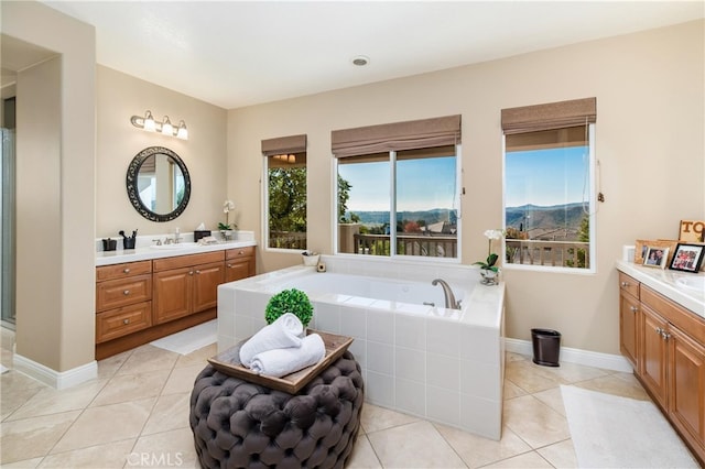 bathroom with vanity, tiled bath, and tile patterned floors