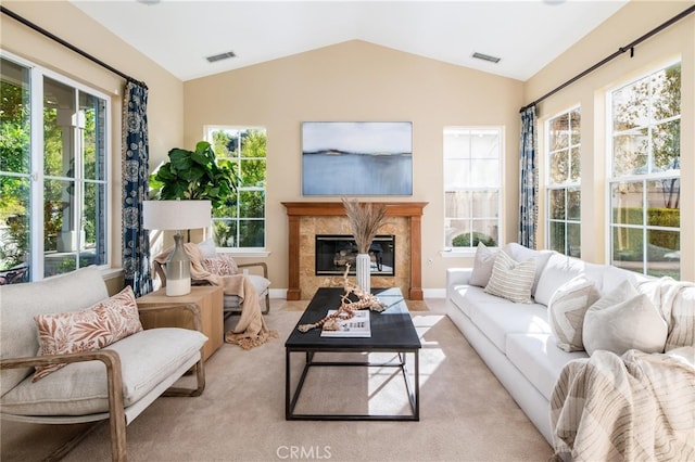 carpeted living room featuring plenty of natural light, a premium fireplace, and vaulted ceiling