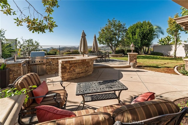 view of patio featuring an outdoor kitchen and a grill